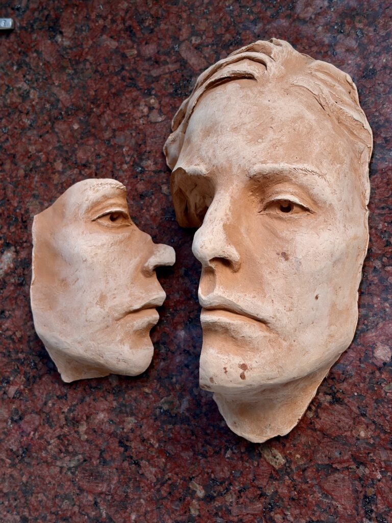Terracotta portrait of a woman on red granite by sculptor Vasil Hajigrudev, 2025